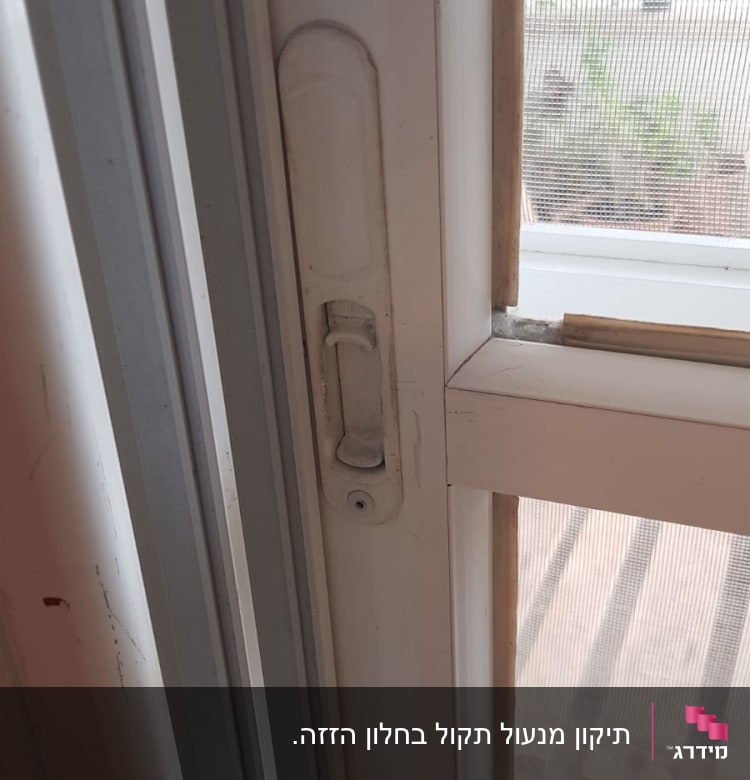 ידית תריס לבנה על חלון זכוכית